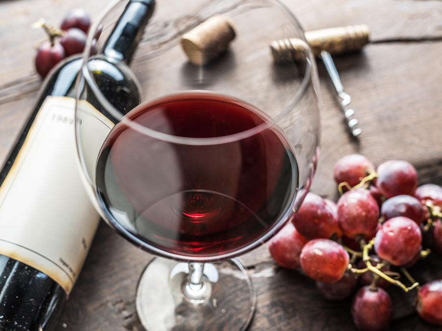 Wine glass, wine bottle and grapes on wooden background. Wine tasting.